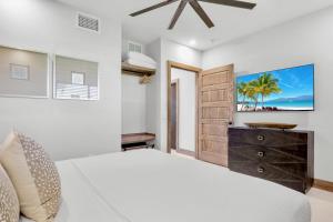 a bedroom with a bed and a tv on the wall at Bali Hai Beach Resort in Holmes Beach +67 photos