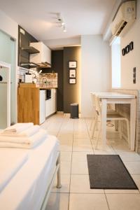 a room with a white table and a kitchen at #Tyrtaiou Modern Design Studio in Mytilene