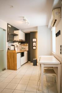 a kitchen with a table and a white table at #Tyrtaiou Modern Design Studio in Mytilene