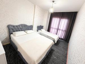 a hotel room with two beds and a window at CİTY HOME tüyap in Esenyurt