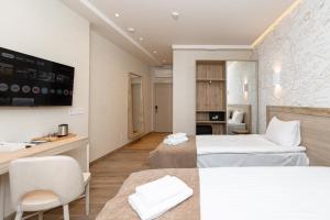 a hotel room with two beds and a desk at Leomare in Odesa