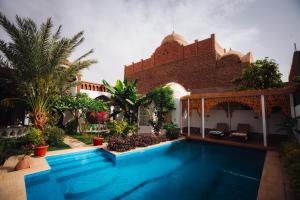 a swimming pool in front of a house at Villa Kemet in Jazīrat al ‘Awwāmīyah