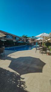 a patio with chairs and umbrellas next to a pool at Safira Praia Hotel in Porto Seguro +57 photos