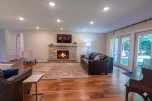 a living room with a couch and a fireplace at Stunning Ranch in the woods in Berrien Springs +17 photos