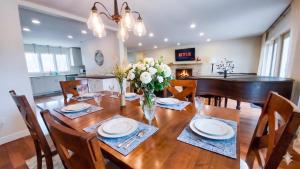 a dining room with a wooden table with a vase of flowers at Stunning Ranch in the woods in Berrien Springs