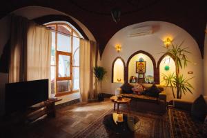 a living room with a couch and some windows at Villa Kemet in Jazīrat al ‘Awwāmīyah