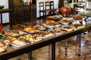 a table with various pastries and pies on it at Cabanas do Morro in Serra Negra