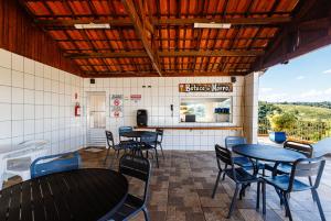a restaurant with tables and chairs and a kitchen at Cabanas do Morro in Serra Negra