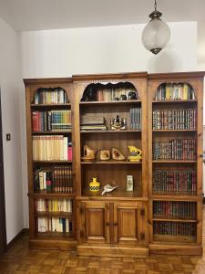 a large wooden book shelf filled with books at Sea & Books Studio in Trieste