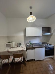 a kitchen with a table and a sink and a microwave at Sea & Books Studio in Trieste