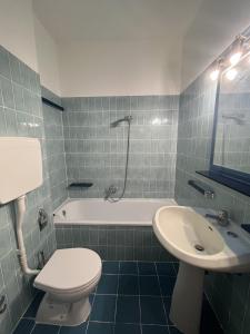 a bathroom with a toilet and a tub and a sink at Sea & Books Studio in Trieste