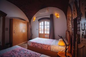 a bedroom with two beds and a window at Villa Kemet in Jazīrat al ‘Awwāmīyah +37 photos