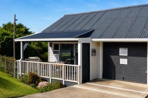 a house with a black roof and a garage at Die Fijnbos in Glentana
