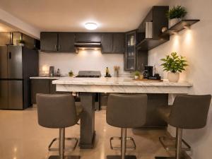 a kitchen with a large counter with chairs in it at Casa Di Manuelito in Monterrey