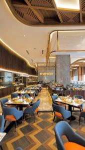a restaurant with tables and chairs in a room at 1 Bedroom Apartment in Aeon Towers I City Views I Free Wi-fi, Gym and Pool in Davao City