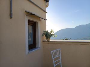 a white chair sitting on a balcony with a window at Affittacamere La Casa Dei Nonni in Polizzi Generosa