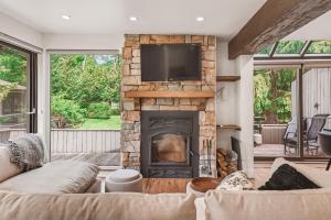 a living room with a fireplace with a tv on top at 206 Val-des-Neiges - MSA LUX in Beaupré