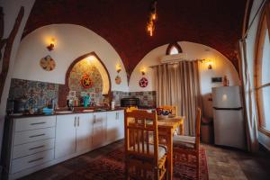 a kitchen with white cabinets and a table and a refrigerator at Villa Kemet in Jazīrat al ‘Awwāmīyah