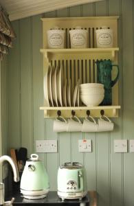 a kitchen with a toaster and dishes on shelves at The Barraghan in Derrygonnelly