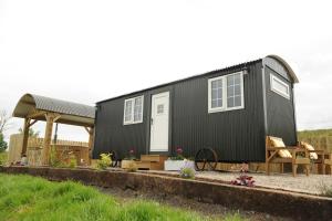 a black tiny house with a gazebo at The Barraghan in Derrygonnelly
