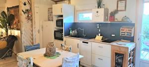 a kitchen with a table and a table and a kitchen with a counter at Chalet La Caz'à Joooh in Rivières