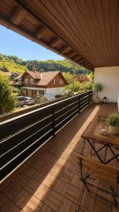 a large deck with a table and benches on it at Allgäu Ferienhaus 5 Apartments mit Sauna,Balkon, Garten und Privatparkplatz in Blaichach