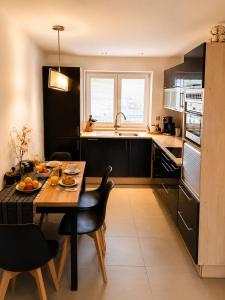 a kitchen with a wooden table and chairs in a kitchen at Apartmán Višňovka in Pardubice