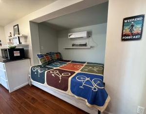 a bedroom with a bed with a comforter on it at HT Innhabit rooftop view suite in Medicine Park