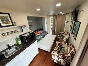 a small room with a sink and a bedroom at HT Innhabit rooftop view suite in Medicine Park