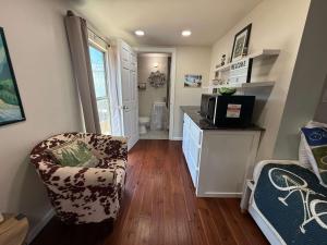 a living room with a chair and a microwave at HT Innhabit rooftop view suite in Medicine Park +34 photos