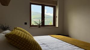 a bedroom with a bed and a window with a view at Casa BuganVilla de Gredos in Mombeltrán