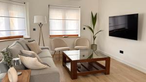 a living room with a couch and a tv at Casa BuganVilla de Gredos in Mombeltrán +18 photos