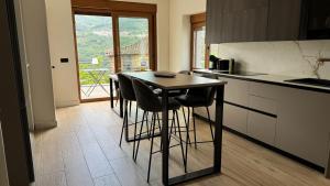 a kitchen with a table and some chairs in it at Casa BuganVilla de Gredos in Mombeltrán