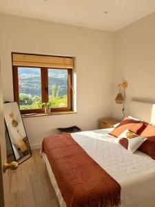 a bedroom with a large bed and a window at Casa BuganVilla de Gredos in Mombeltrán