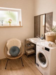 a laundry room with a washing machine and a sink at Glamping Tisá in Tisá