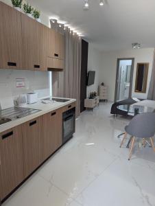 a large kitchen with wooden cabinets and a dining room at Shamrock Flats in Mellieħa