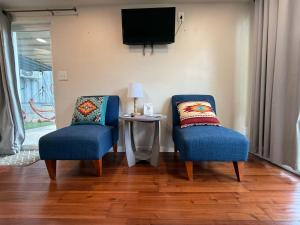 two blue chairs sitting next to a table with a tv at PPI Native American Theme suite in Medicine Park
