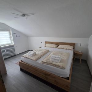 a bedroom with a large bed with white sheets at Im Buchenweg in Großheubach
