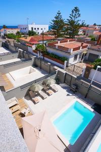 a swimming pool on top of a building with umbrellas at Sun&Fun Villa in Vinarós