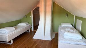 two beds in a room with green walls at Mysigt torp på bondgård in Lämmedal
