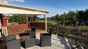 a wooden deck with chairs and a pavilion at Mysigt torp på bondgård in Lämmedal