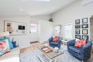 a living room with two blue chairs and a table at Granite Cottage in Rockport