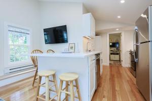 a kitchen with a large white counter and stools at Granite Cottage in Rockport +18 photos
