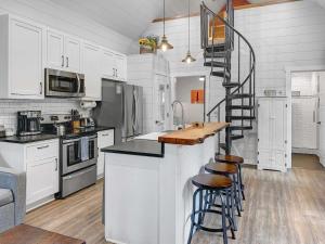 a kitchen with white cabinets and a spiral staircase at Island Retreat - Great for Large Groups in Charleston