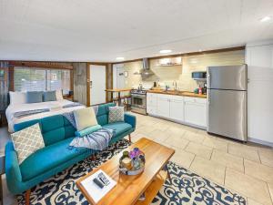 a living room with a blue couch and a kitchen at Island Retreat - Great for Large Groups in Charleston
