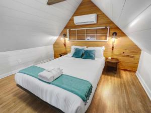 a bedroom with a bed with white sheets and blue pillows at Island Retreat - Great for Large Groups in Charleston