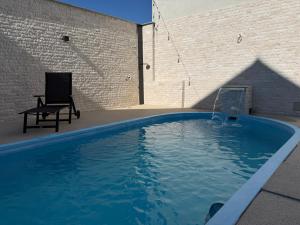 a swimming pool with a chair next to a brick wall at New Venus in Curtea de Argeş