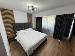 a bedroom with a large bed and a window at New Venus in Curtea de Argeş +30 photos