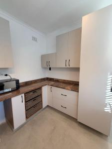 a kitchen with white cabinets and a counter top at Stirling House in Mooiriver