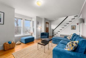 a living room with blue couches and a staircase at Helena House in Gloucester